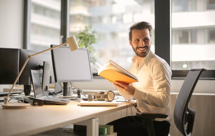 Man in an office holding a book