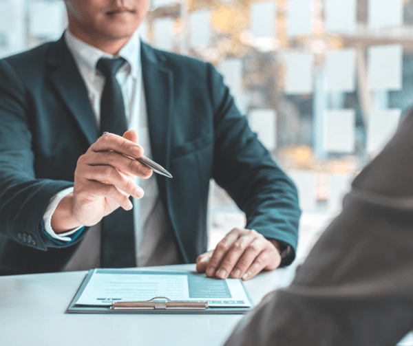 Strong employer brand Man is business suit holding pen and sitting at table while interviewing a potential employee